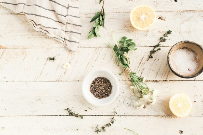 Fresh food ingredients, including a halved lemon, herbs, and dried lavender, arranged on a rustic wooden table for a natural and healthy food preparation scene.